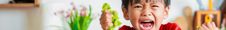 Boy holding lettuce and screaming.